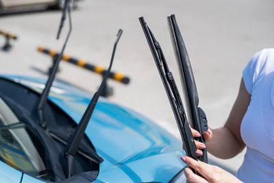 Midsection of man holding umbrella on car