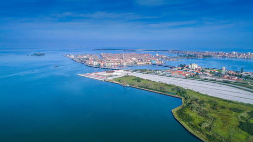 High angle view of cityscape by sea against sky