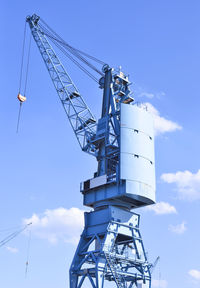 Low angle view of crane on pier against sky