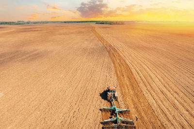 Scenic view of agricultural field against sky during sunset