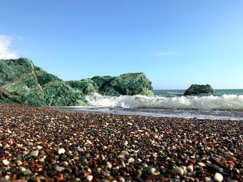 Surface level of stones on beach against sky