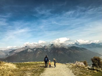 Rear view of people on mountain against sky