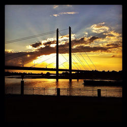 Bridge over river at sunset