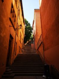 Low angle view of alley amidst buildings in city