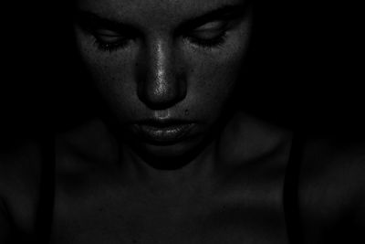 Close-up of stressed young woman in darkroom