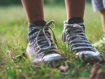 Low section of man wearing shoes on field