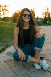 Portrait of smiling young woman sitting outdoors