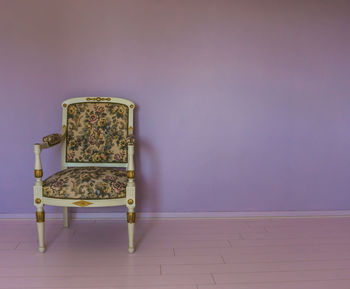 Empty chair and table against wall at home