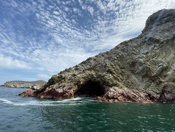 Rock formation in sea against sky