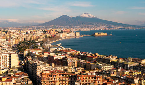 High angle view of city by sea against sky