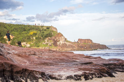 Scenic view of cliff by sea against sky