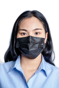 Portrait of teenage girl covering face against white background