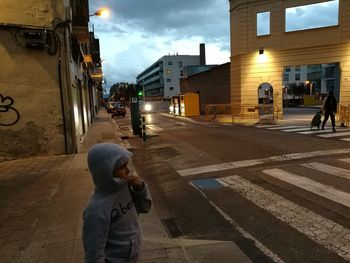 Rear view of boy playing on street