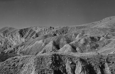 Scenic view of snowcapped mountains against sky at night