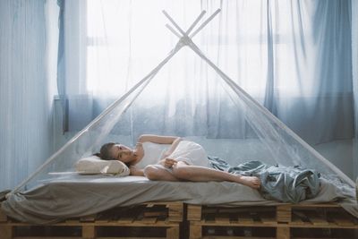 High angle view of woman lying on bed