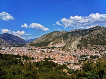 Aerial view of townscape and mountains against sky