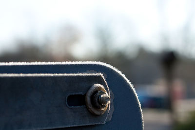 Close-up of machine part against sky