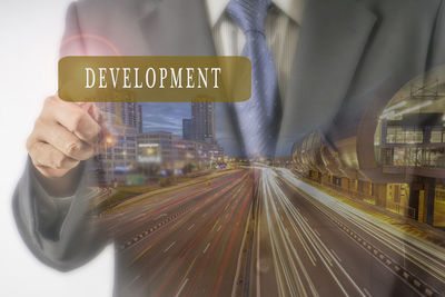 Double exposure image of businessman with development text and illuminated city