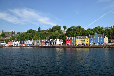 Scenic view of lake by buildings against sky