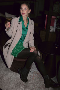 Portrait of young woman sitting on floor