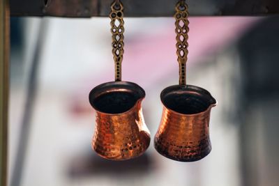 Two coffeecpots hanging on metal