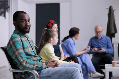 Side view of people sitting on table