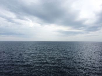 Scenic view of calm sea against cloudy sky