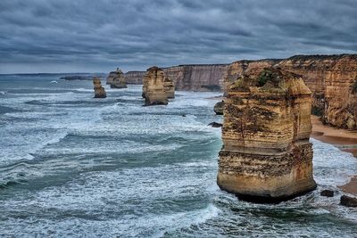 Idyllic shot of twelve apostles sea rocks in sea against cloudy sky