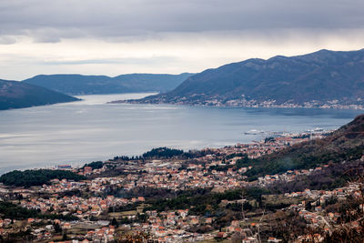 Aerial view of townscape by sea against sky