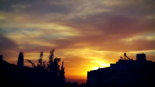 Silhouette built structures against scenic sky