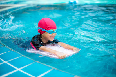 Smiling girl swimming in pool