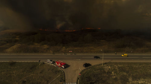 Massive fire, dry grass lanes in fire, firefighters at work, disaster, ecological catastrophe