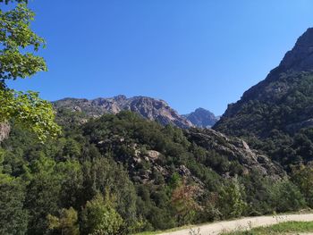 Scenic view of mountains against clear blue sky