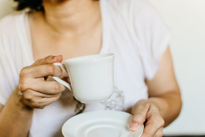 Midsection of woman holding coffee cup