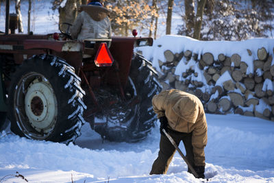 Rear view of man working on snow field