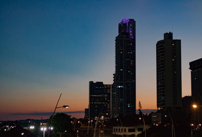 Modern buildings against sky at night