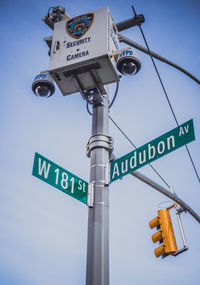 Low angle view of road sign against blue sky