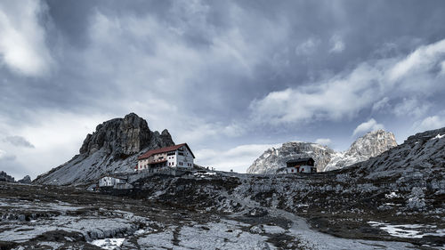 Built structure on snowcapped mountain against sky