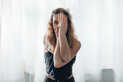 Side view of young woman looking away while standing at home