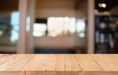 Close-up of empty wooden table in illuminated building