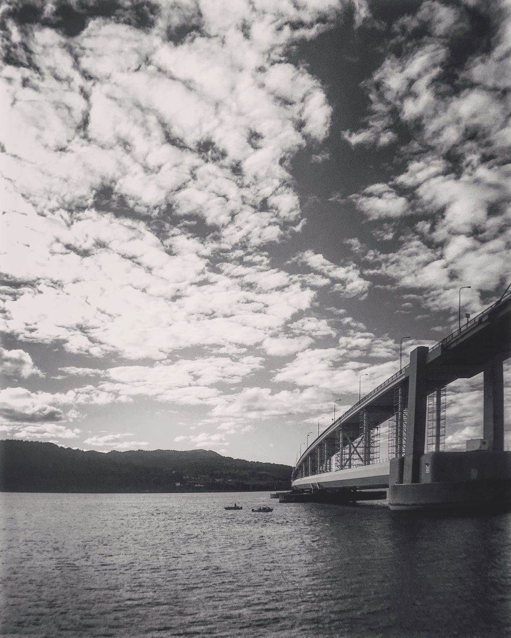 water, bridge - man made structure, connection, built structure, architecture, sky, transportation, mountain, waterfront, scenics, tranquil scene, engineering, river, cloud, cloud - sky, tranquility, bridge, suspension bridge, nature, day, beauty in nature, outdoors, calm, mountain range, sea, no people, tourism, non-urban scene, long, majestic