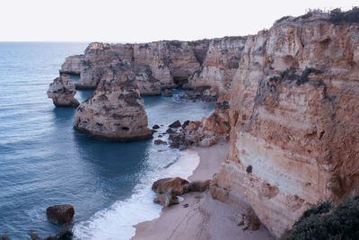 Rock formations in sea against sky