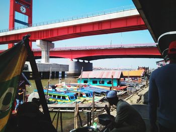 Rear view of people standing on bridge in city