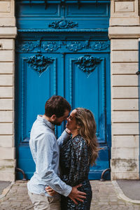 Young couple standing against building