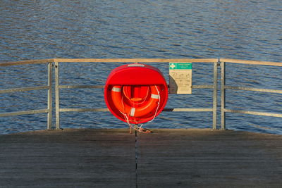 Red umbrella hanging on rope against sea