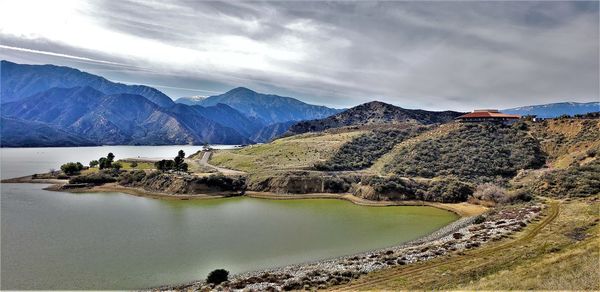 Scenic view of lake by mountains against sky