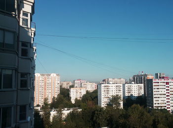 Low angle view of apartment buildings against clear blue sky