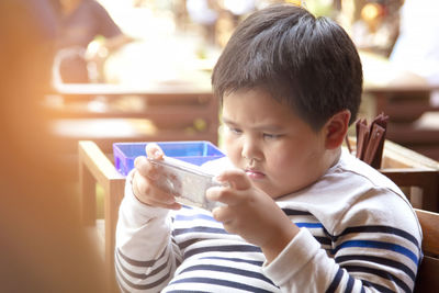 Cute boy using mobile phone at home