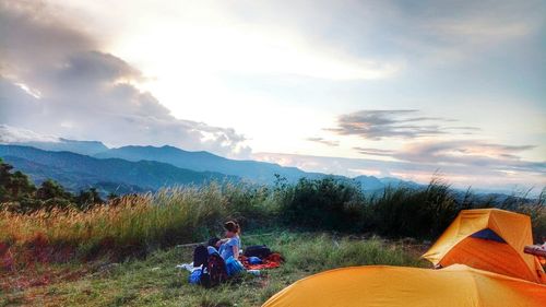 People sitting on mountain against sky