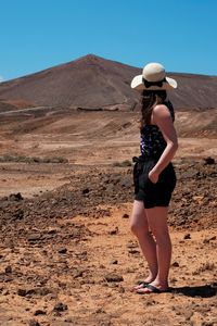 Rear view of woman standing in desert
